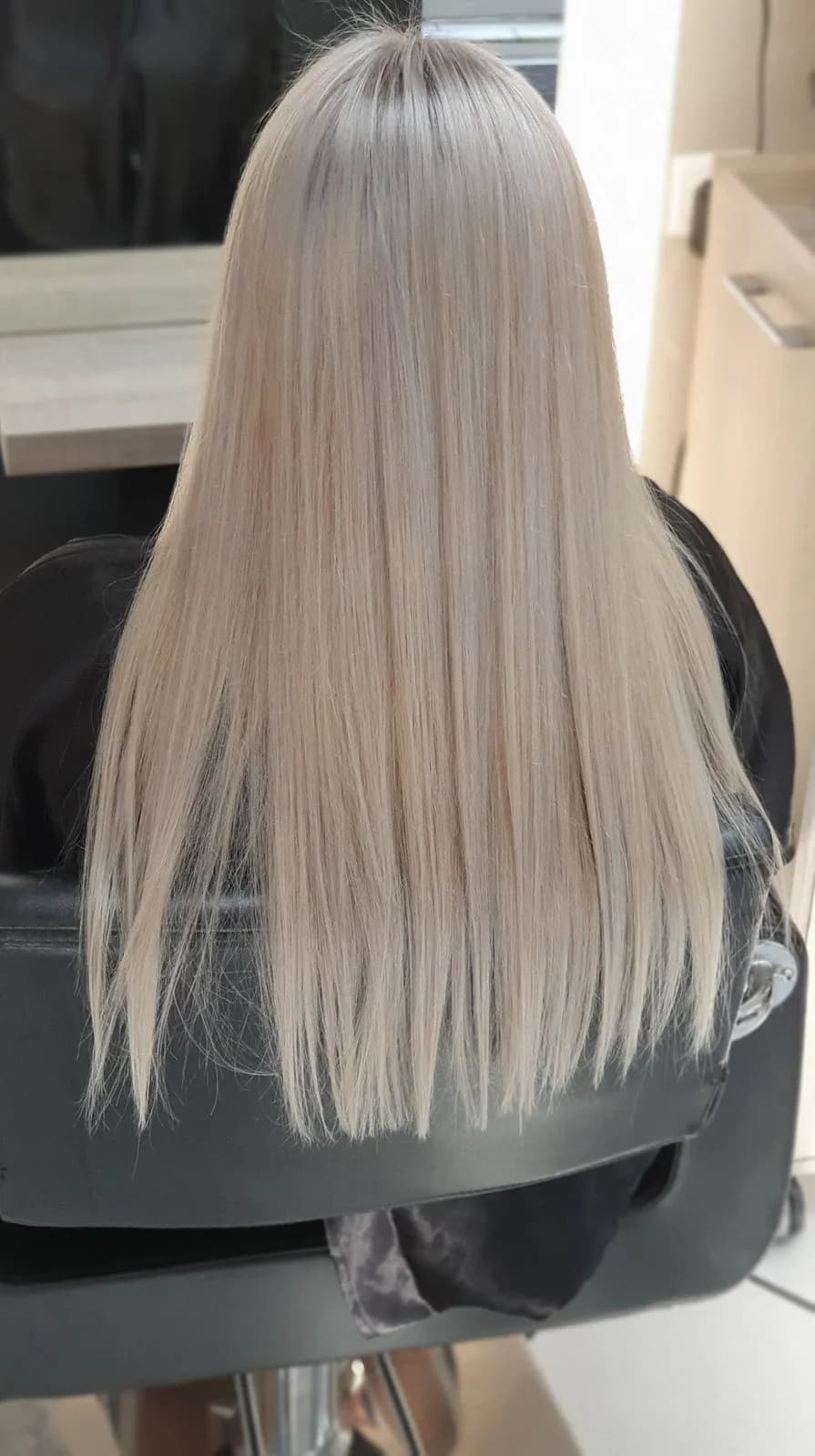 Cheveux longs blonds lissés, vus de dos, au salon