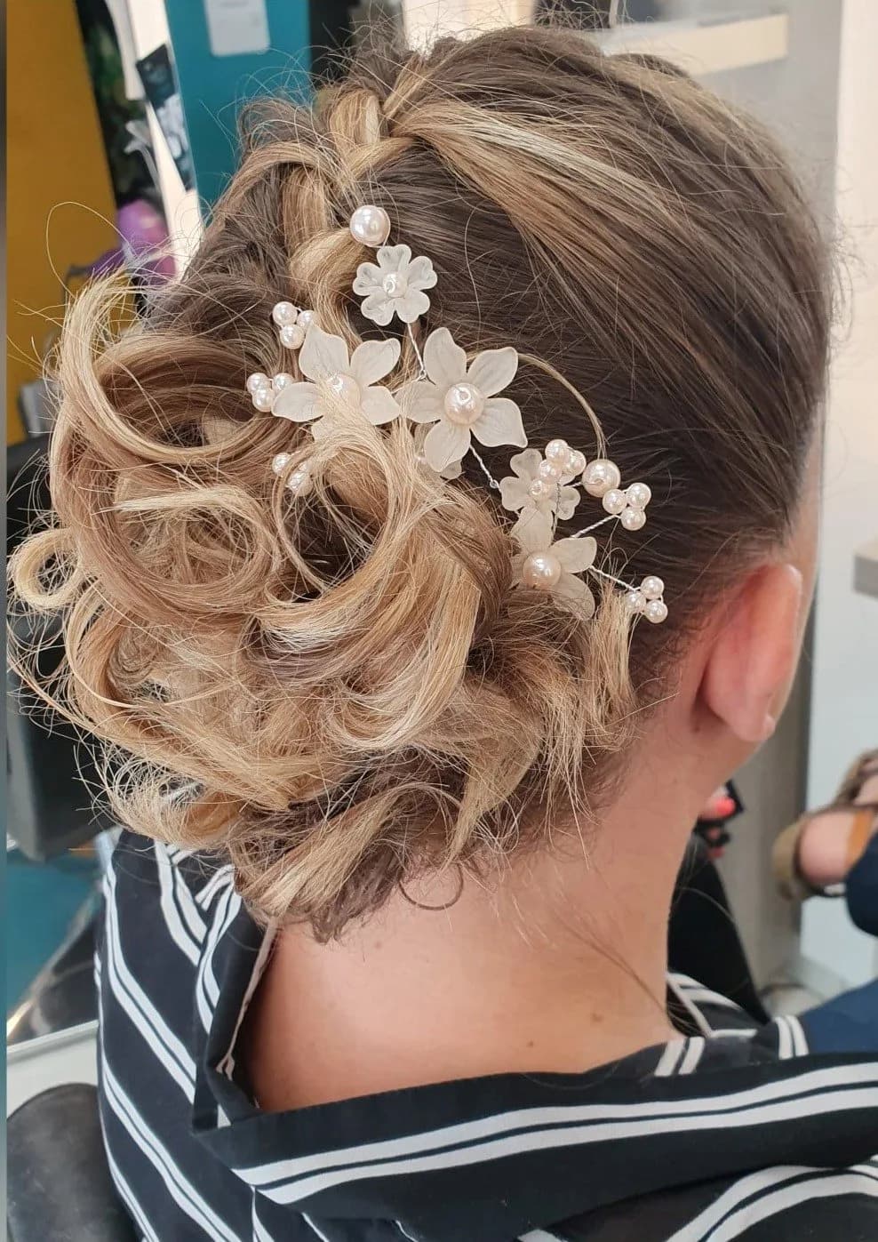 Chignon de mariage bouclé orné de fleurs, vu de dos