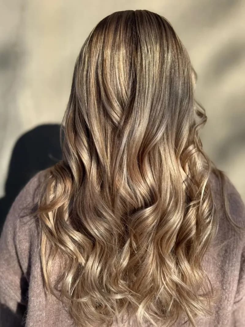 Cheveux longs bouclés, balayage châtain et blond, vus de dos