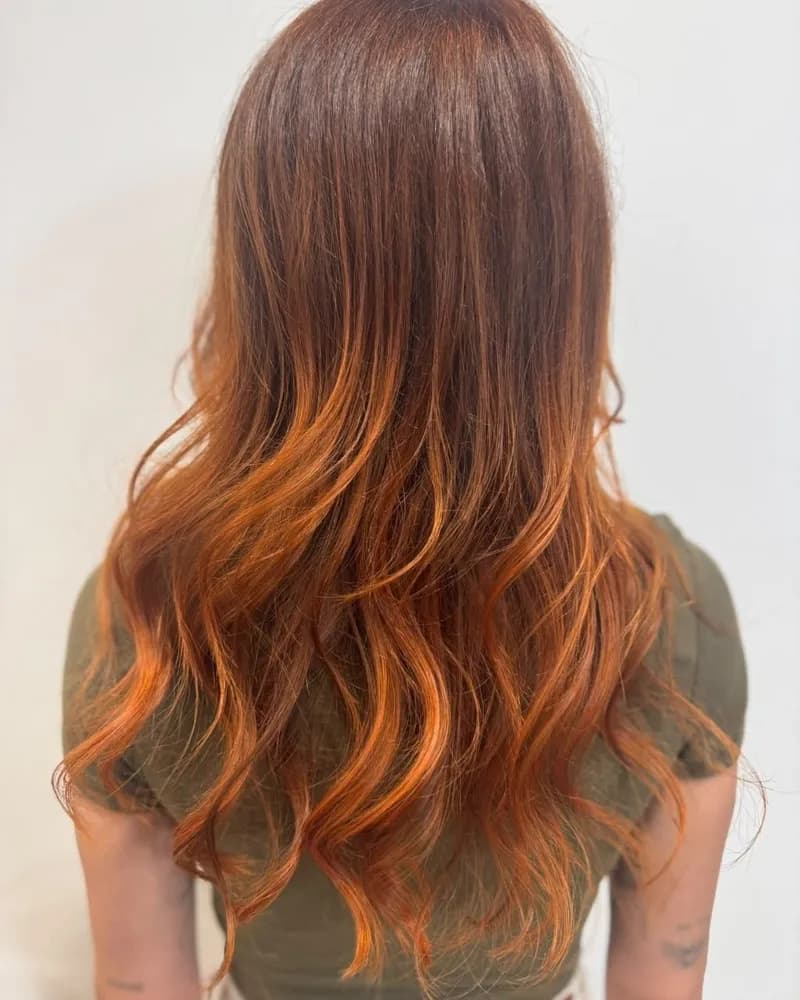 Cheveux longs, coloration cuivrée intense sur les longueurs, vus de dos