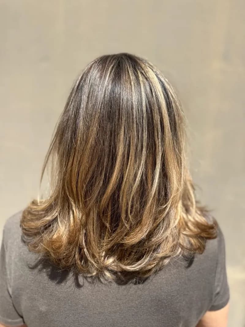 Cheveux mi-longs dégradés, balayage blond et patine végétale, vus de dos